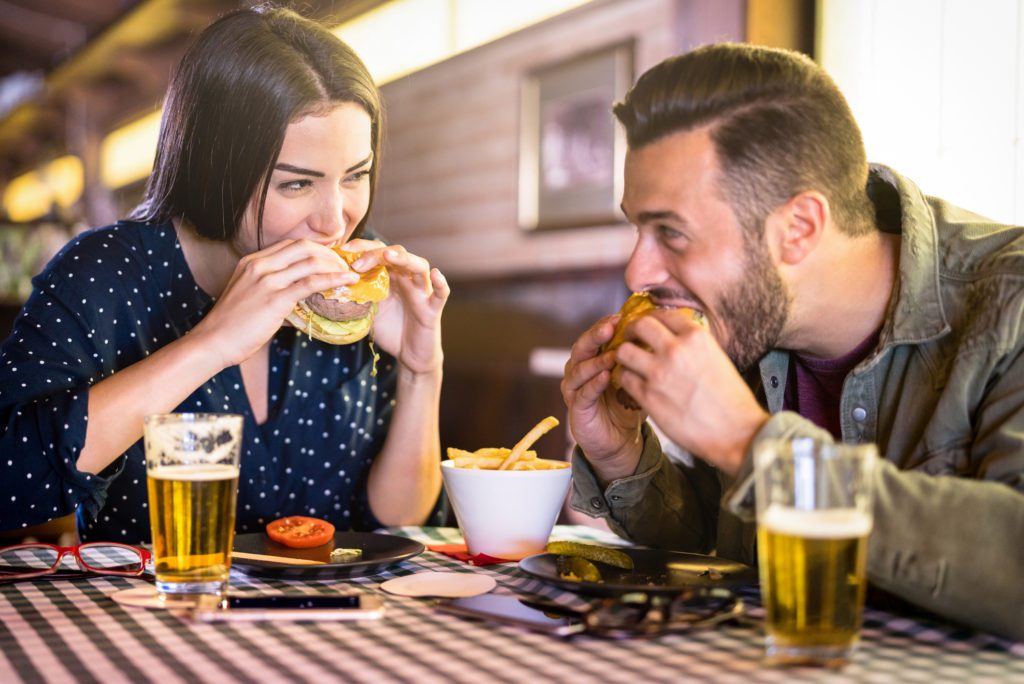 a couple enjoying a beer and a burger at Barefoot Landing.