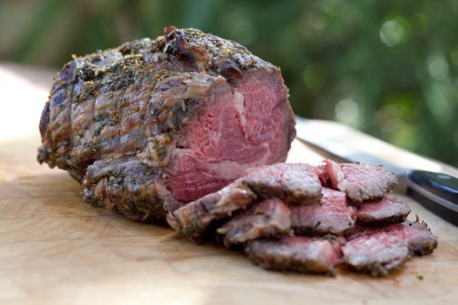 Large cut of roast beef ready to slice