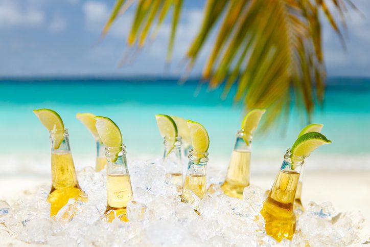 Beers with limes under a palm tree on a beach